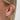 Tjej använder ear cuff med tre guldringar och vita kristaller