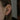 Guldpläterade piercingsmycken och örhängen på stylat öra, med dekorativ ear cuff, gröna kristaller och flera små guldsmycken.