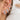 Närbild på öra med flera silverfärgade hoops och ear cuffs med klara kristaller i elegant ear stack.