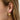 öra smyckat med flätad ear cuff i guld och örhängen.