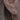 Smyckat öra med flera piercingsmycken i guld.